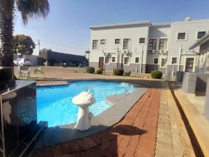 a swimming pool with a statue in front of a house at Lifestyle Lodge Hotel in Vereeniging +12 photos
