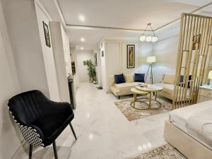 a living room with a bed and a couch and a chair at Cozy Apartment with a King Bed in Lahore