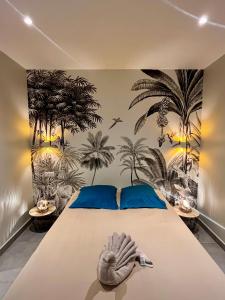 a bedroom with a bed with a mural of palm trees at Villa Ti Lagon in Sainte-Luce +38 photos