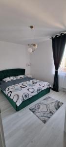 a bedroom with a bed with a black and white comforter at Apartament central pe pietonala nr2 in Hunedoara