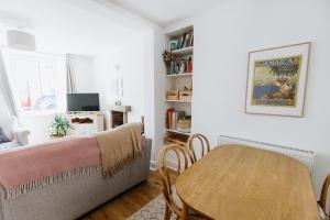 a living room with a table and a couch at SUN COTTAGE - Cosy Cottage in Ulverston with a log burner in Ulverston, Cumbria in Ulverston