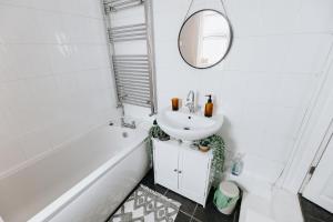 a white bathroom with a sink and a mirror at SUN COTTAGE - Cosy Cottage in Ulverston with a log burner in Ulverston, Cumbria in Ulverston +20 photos