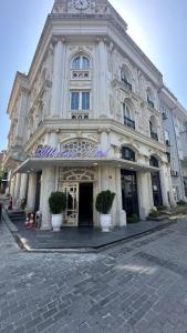 a large white building with potted plants in front of it at NkALBATROS HOTEL in Istanbul