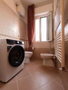 Un baño con lavadora y un inodoro. en Felix Apartment, en Pisa
