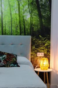 Un dormitorio con una cama y una mesa con una lámpara. en APARTAMENTO La MARIA2, en Málaga