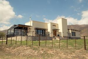 a house on a hill with mountains in the background at Malaica in Tafí del Valle