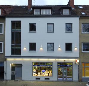 a white building with lights on the facade at Cityapartment An der Petrikirche in Braunschweig