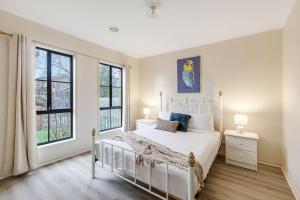 墨尔本Heart of McKinnon Units by Ready Set Host的一间卧室，有一张白色的床和两扇窗户