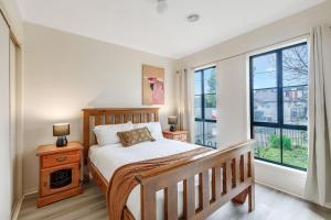 墨尔本Heart of McKinnon Units by Ready Set Host的带一张床和两扇窗户的卧室 更多37张照片