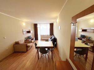 a room with a table and chairs and a living room at PM Services Sequoia Apartment in Borovets