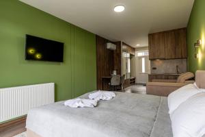 a bedroom with green walls and a bed with white sheets at Garda - Breakfast included in the price Restaurant Free Parking Mountain view Kitchen in the apartment separate entrance in Bukovel
