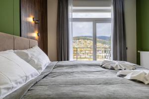 a bedroom with a large bed with a large window at Garda - Breakfast included in the price Restaurant Free Parking Mountain view Kitchen in the apartment separate entrance in Bukovel