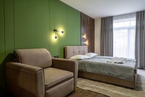 a green bedroom with a bed and a chair at Garda - Breakfast included in the price Restaurant Free Parking Mountain view Kitchen in the apartment separate entrance in Bukovel