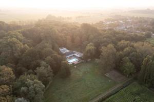 an aerial view of a house in the trees at Villa met privézwembad, 10 minuten van het strand in Noordwelle
