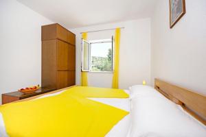 a yellow bed in a white room with a window at House Tonko in Postira +45 photos