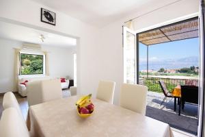 a dining room with a table with a bowl of fruit on it at House Tonko in Postira