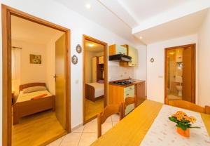 a kitchen and dining room with a table and a bedroom at Apartment San in Povljana