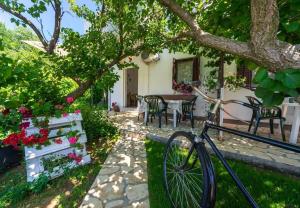 a bike parked in front of a house with a table and chairs at Apartment San in Povljana