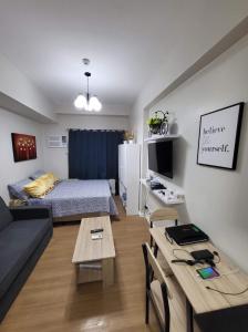 カガヤン・デ・オロにあるStudio Condo at The Loop Tower, Limketkai Dr, Cagayan de Oro Cityのベッドとテーブルのあるリビングルーム