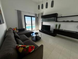 a living room with a couch and a television at Nazaret Home in Nazaret