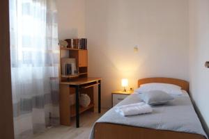a small bedroom with a bed and a desk with a microwave at House Toncica in Dol