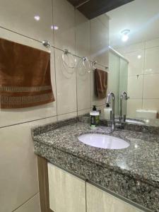 une salle de bain avec un lavabo et un miroir dans l'établissement Apartamento Inteiro - 2 Quartos com AC - Wifi 300mb - Cozinha Completa - 1 Vaga de Garagem - TV Smart 50 - Sacada - Indicado para Grupos, Hospedes a Trabalho, Família e Pets, à Toledo