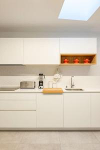 a white kitchen with white cabinets and a sink at EDEN RENTALS La Laguna Heritage Residence in La Laguna