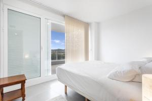 a bedroom with a bed and a large window at Tarongers in Canet de Berenguer +21 photos
