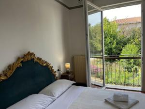 een slaapkamer met een bed en een groot raam bij Abano Comfort Apartment Terme in Abano Terme +23 foto's