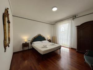 アーバノ・テルメにあるAbano Comfort Apartment Termeのベッドと木の床のある寝室
