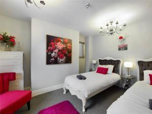 a bedroom with two beds and a painting on the wall at Montague House Town Centre Sleeps Up To 12 Guests in Ross on Wye