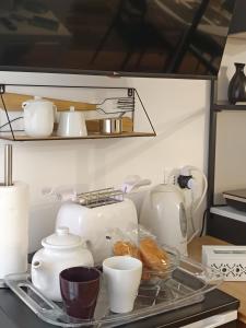 ein Tablett mit Geschirr und Tassen auf einem Regal in der Unterkunft Dimora al Capo in Palermo
