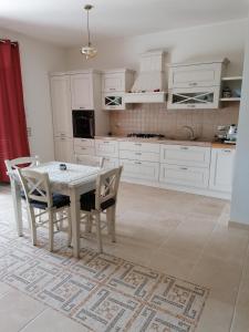 a white kitchen with a white table and chairs at Il boschetto da Michael -nocciolo in Badia Al Pino +14 photos