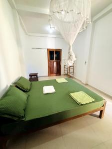 a bedroom with a green bed in a room at Nihal Bay View in Matara