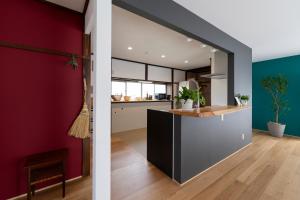 a kitchen with red walls and a counter in a room at Rabbit Inn in Fuji