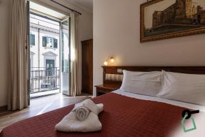 a bedroom with a bed with towels on it at HOTIDAY Room Collection - Palermo Politeama in Palermo