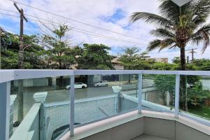 a balcony with a view of a street and palm trees at Marmeu Enseada in Guarujá