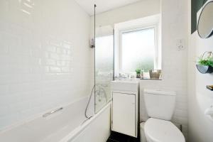 ein weißes Badezimmer mit Toilette und Dusche in der Unterkunft Elegant 2BR Aylesbury Home, Sleeps 4, Parking, Work, Leisure, Friendly in Buckinghamshire