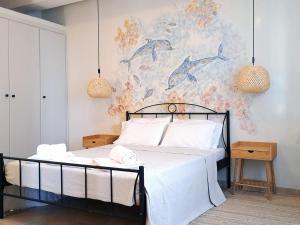 a bedroom with a bed and a painting of dolphins at Sirens Villas in Skopelos Town +67 photos