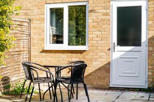 einen Tisch und vier Stühle vor einem Gebäude in der Unterkunft Elegant 2BR Aylesbury Home, Sleeps 4, Parking, Work, Leisure, Friendly in Buckinghamshire
