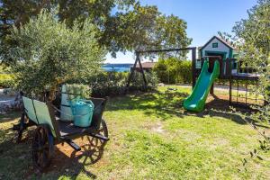 een speeltuin met een kar en een glijbaan bij Villa Vlacich for 8 people near Labin - Rabac with heated pool & sea view - only 2 km from beach in Trget