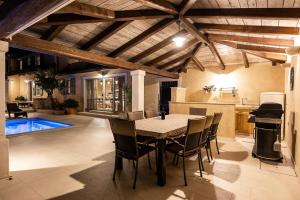 een keuken en eetkamer met een tafel en stoelen bij Villa Vlacich for 8 people near Labin - Rabac with heated pool & sea view - only 2 km from beach in Trget