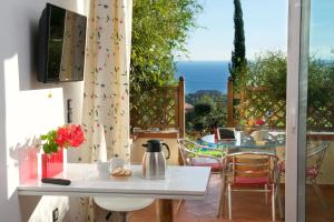 a patio with a table and chairs and a view of the ocean at Felix Residence & Lucia Simona Villas in Mousata
