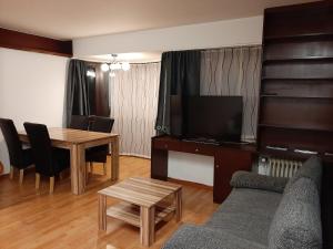 ein Wohnzimmer mit einer Couch und einem Tisch mit einem Fernseher in der Unterkunft City Bonn Apartments in Bonn