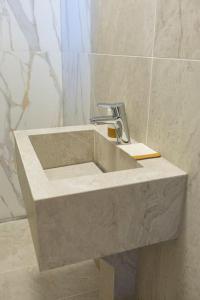 a stone sink in a bathroom with a shower at City Center Apartment in Cluj-Napoca