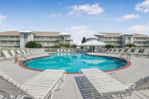 a swimming pool with lounge chairs and a resort at Romar Lakes 104B in Orange Beach