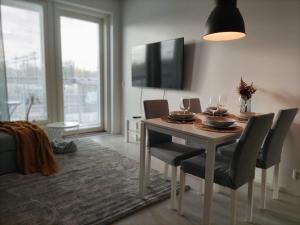 a dining room with a table with chairs and a tv at Kampuksen Tähti in Pori