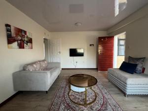 a living room with a couch and a table at Modern Downtown Escape in Gaborone
