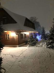 a house covered in snow at night with lights at Liptovská Drevenica in Liptovský Mikuláš