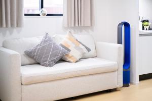 a white couch with pillows on it in a living room at The Peak Tsutenkaku in Osaka +36 photos